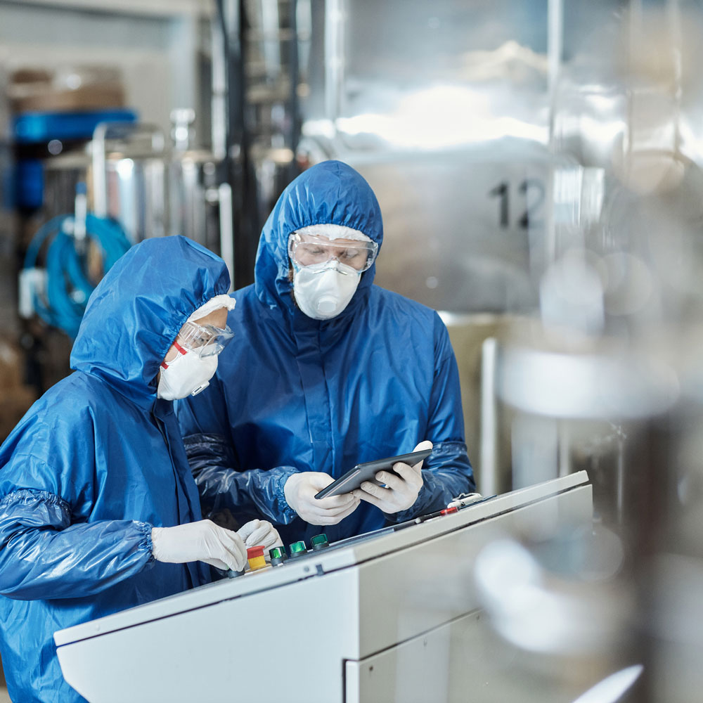 Two factory workers in protective gear