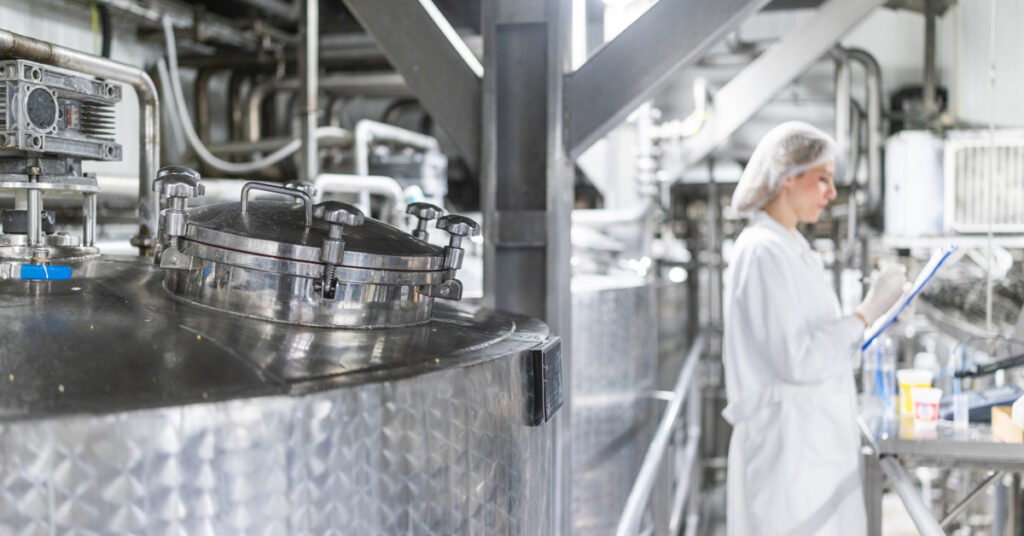 Worker in the background of food processing plant